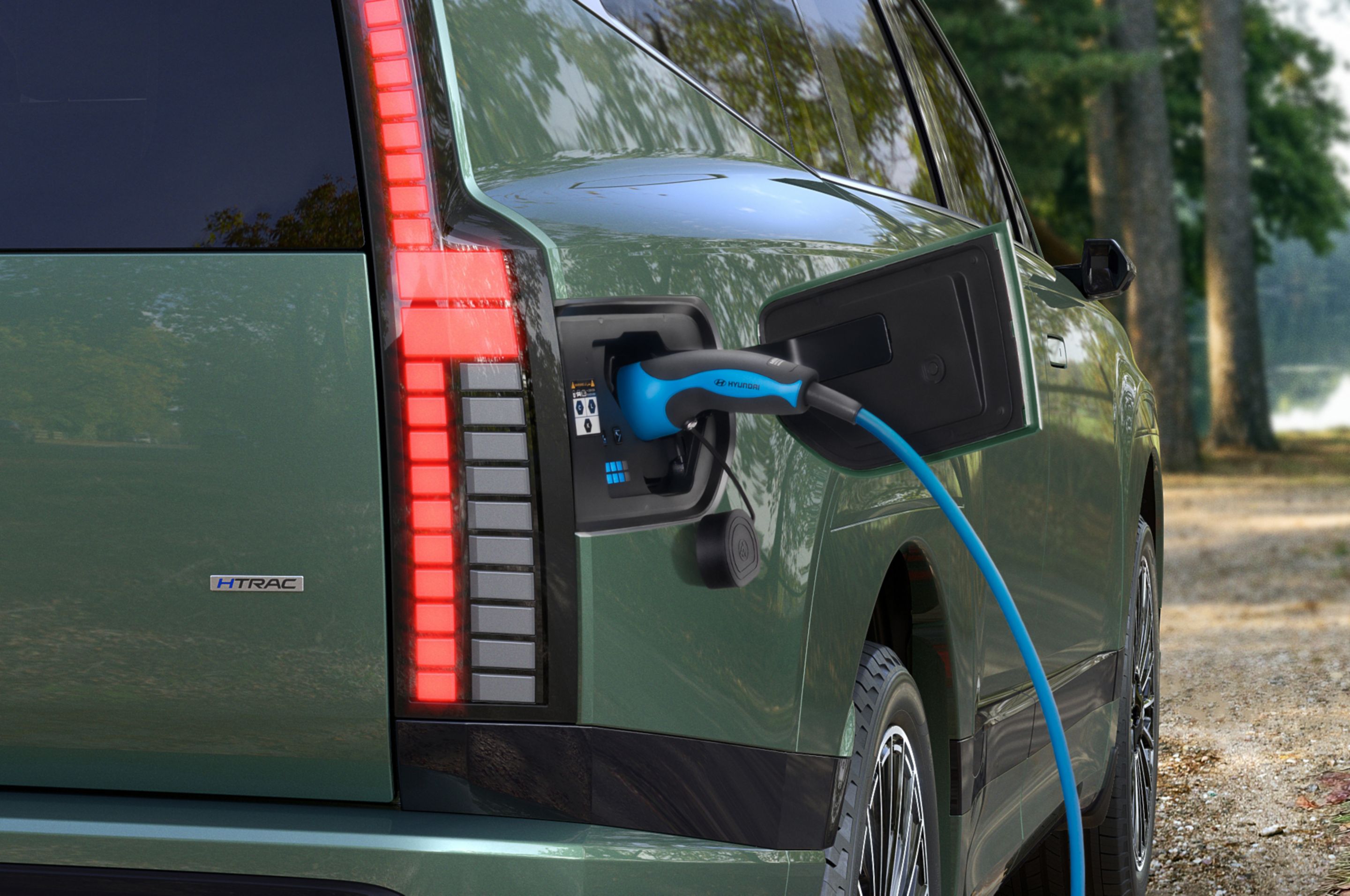 La toma de carga abierta del SUV eléctrico Hyundai IONIQ 9 con el cable de carga conectado.