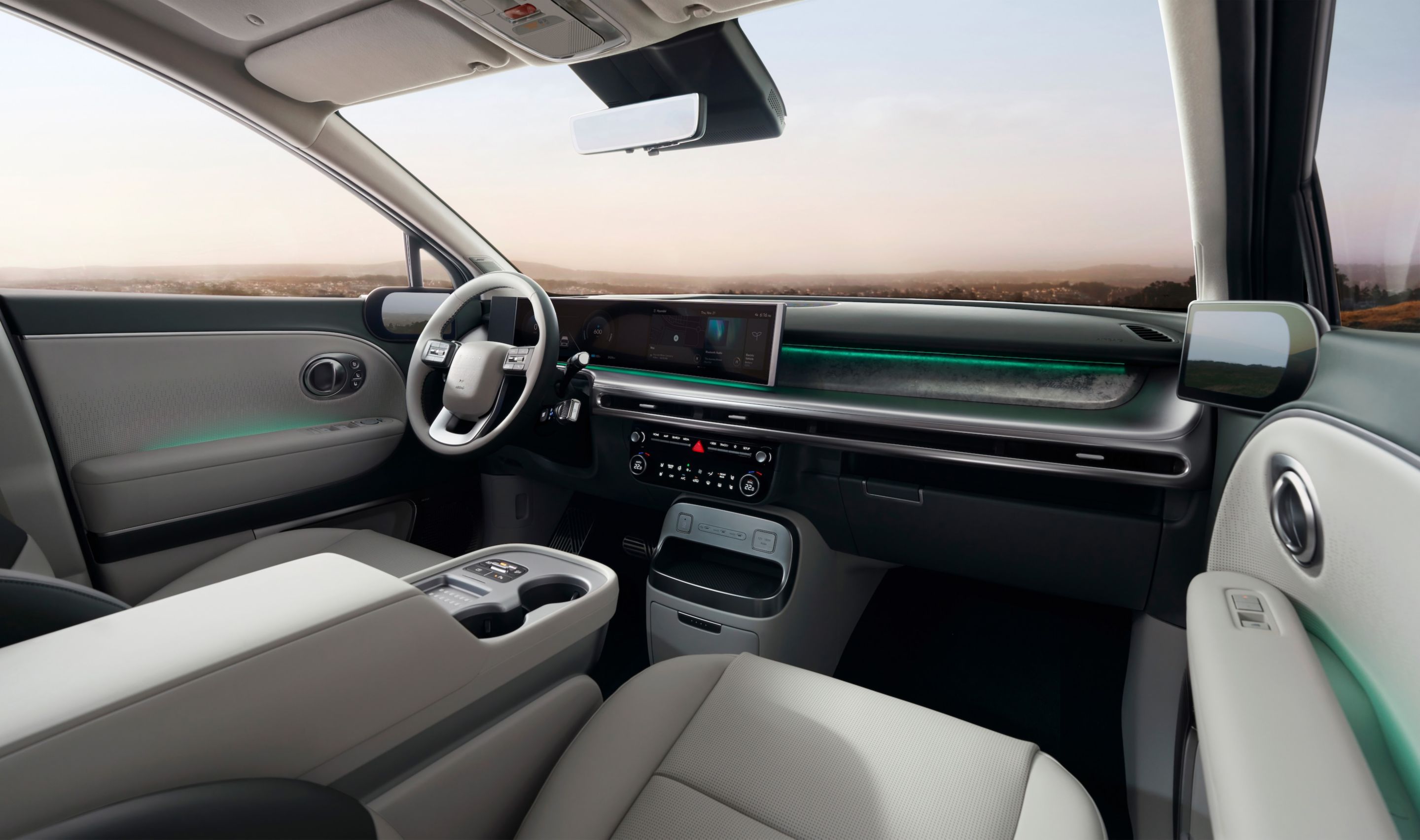 Interior del habitáculo del Hyundai IONIQ 9 mostrando las pantallas integradas y los dos asientos delanteros.