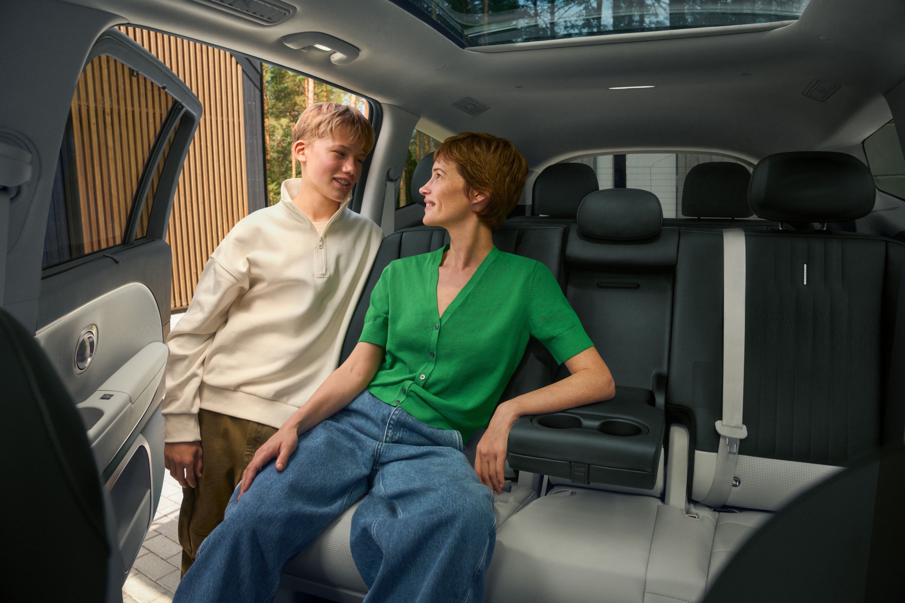 Zona de asientos trasera espaciosa en el Hyundai IONIQ 9 con pasajero y vista abierta de la cabina